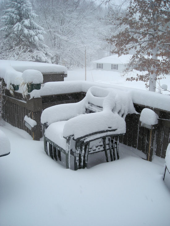 Snow Covered Stack of Chairs